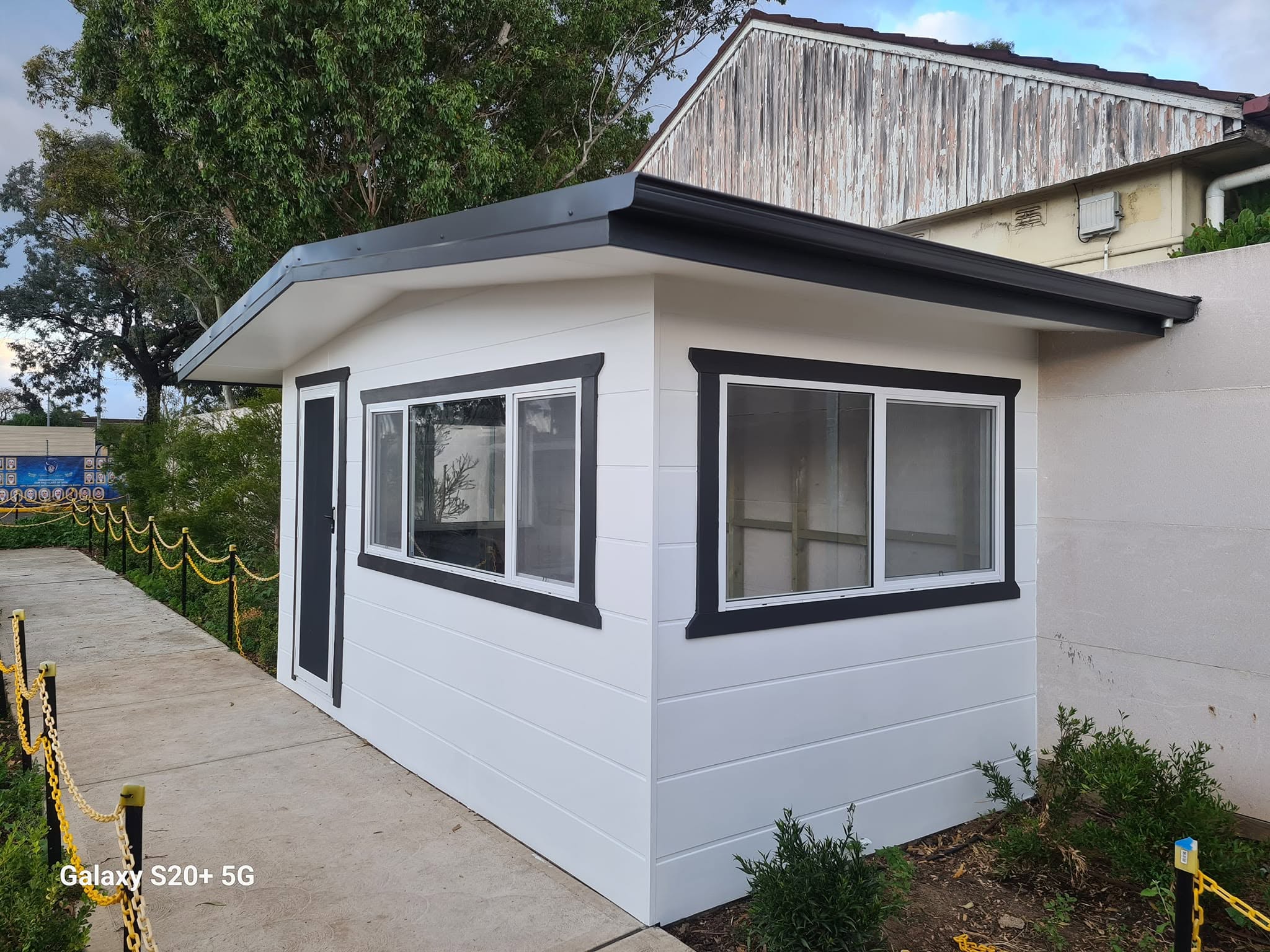 Completed white-clad building with charcoal window frames